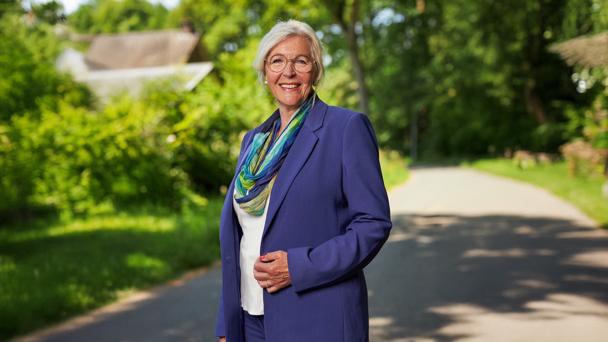 Portretfotografie Groningen – Lachende Vrouw In Paarse Kleding Staande In Groen Bos